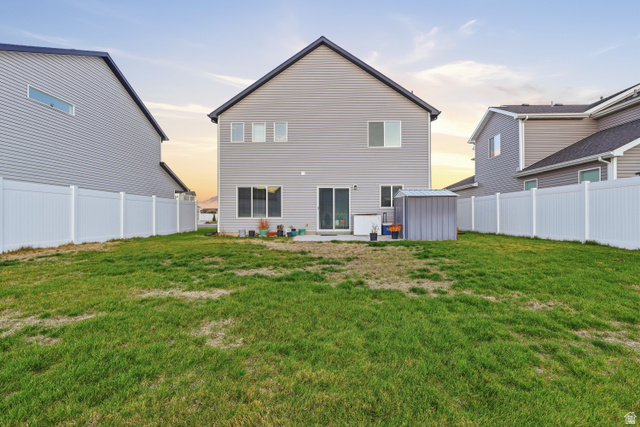 2011 Wren Circle Logan, UT 84339 - Photo 20 of 20 Rear view of property with a partially fenced backyard, a patio, and a storage shed