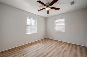 an empty room with a window and ceiling fan