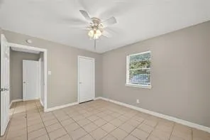 an empty room with fan and windows