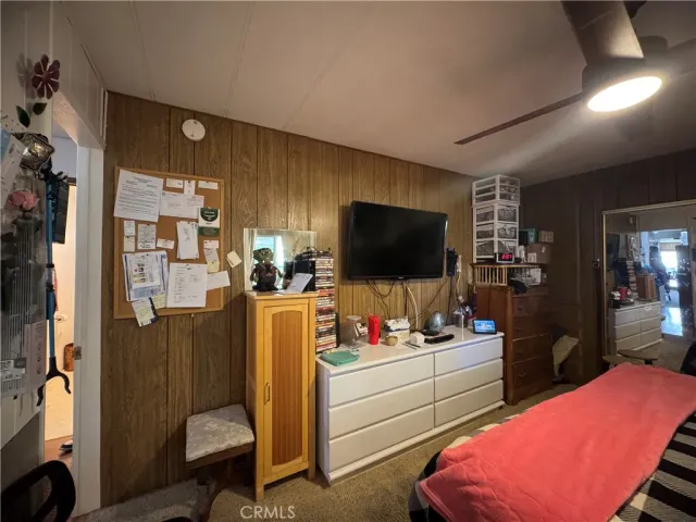 a room with furniture a flat screen tv and a refrigerator