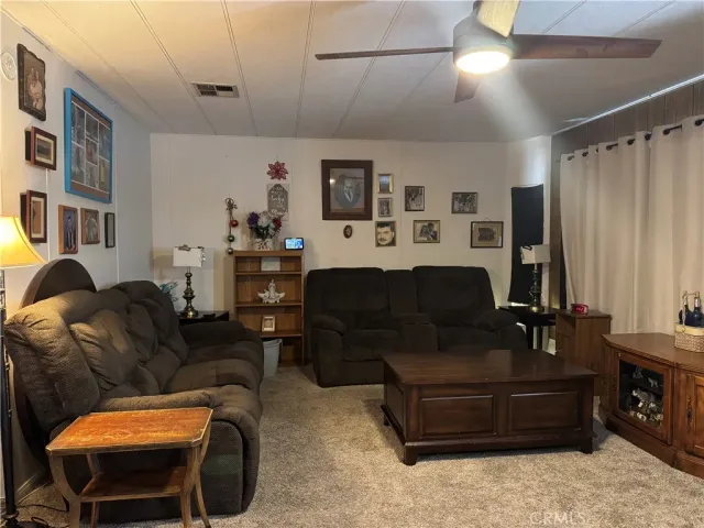 a living room with furniture a ceiling fan and a window