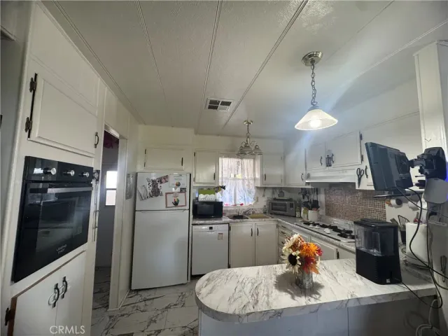 a kitchen with stainless steel appliances granite countertop a sink a stove and a refrigerator