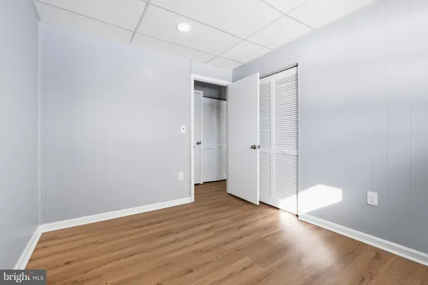an empty room with wooden floor and white walls