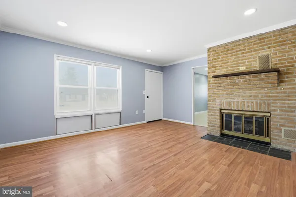 an empty room with windows and fireplace