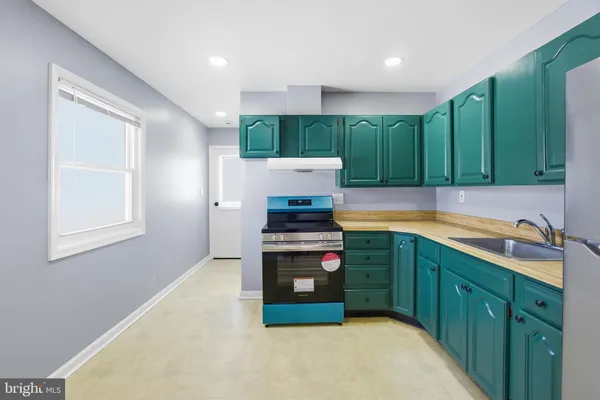 a kitchen with kitchen island granite countertop a stove a sink and a microwave