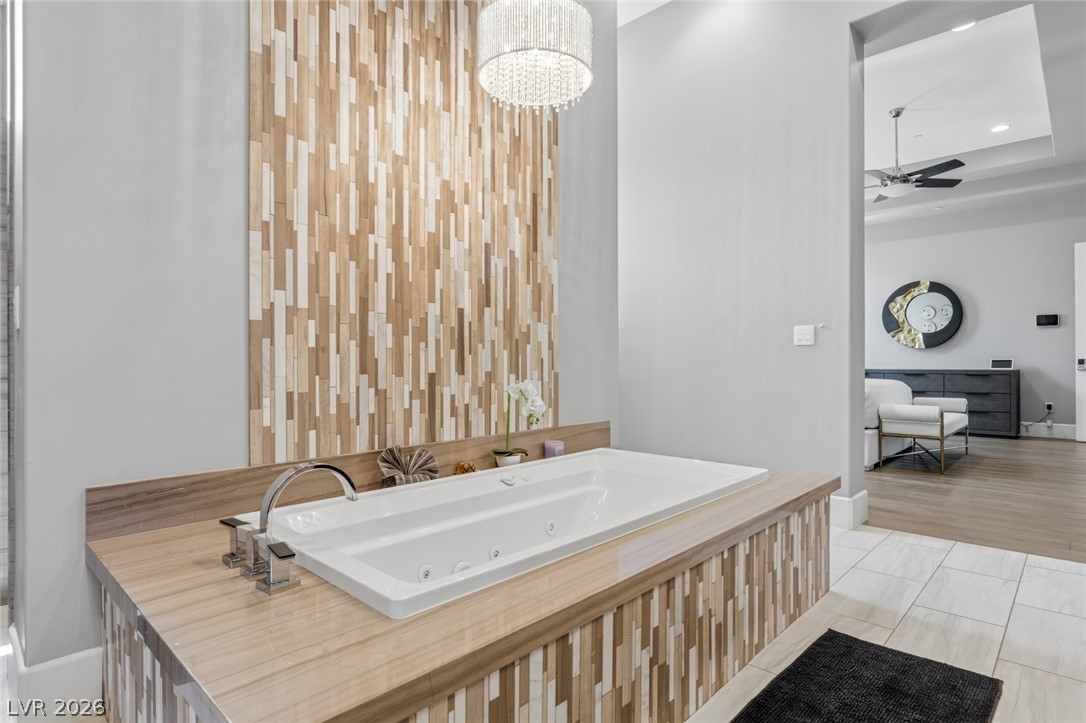 5 Crystal Tree Pass Henderson, NV 89052 - Photo 21 of 67 Indulge in relaxation with this contemporary soaking tub, accented by a striking wood-paneled feature wall and elegant chandelier.