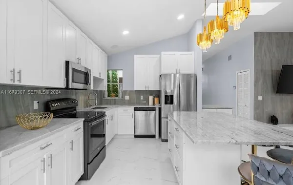 a kitchen with a sink a microwave a refrigerator and cabinets