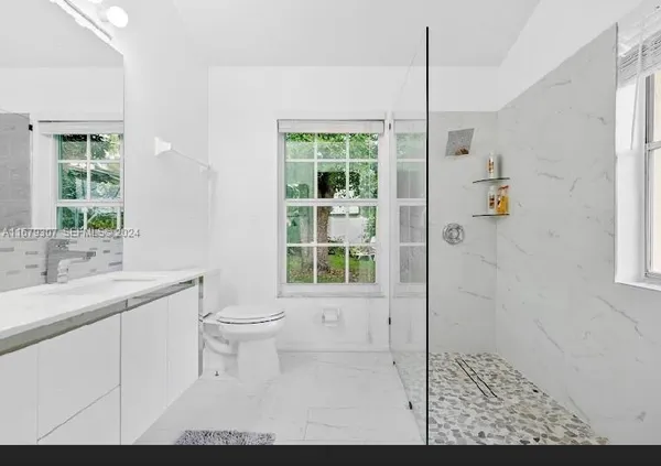 a bathroom with a double vanity sink toilet and shower