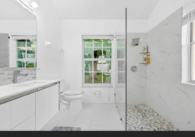 a bathroom with a double vanity sink toilet and shower