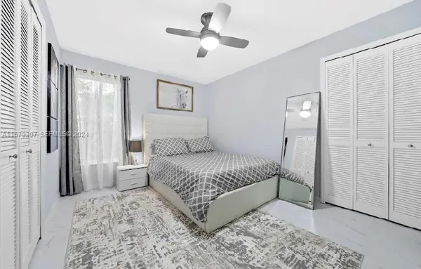 a large bed sitting in a bedroom next to a window and a wooden floor