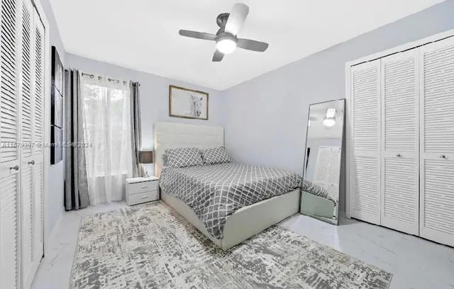 a large bed sitting in a bedroom next to a window and a wooden floor