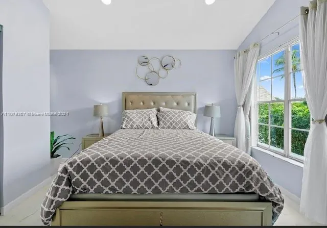 a bedroom with a bed and a potted plant