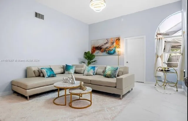 a living room with furniture a rug and a table