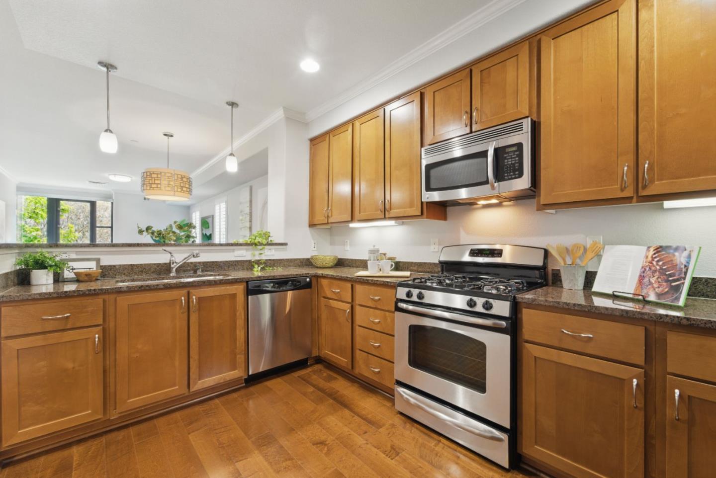 1388 Broadway, Unit 328 Millbrae, CA 94030 - Photo 6 of 25 a kitchen with stainless steel appliances granite countertop wooden cabinets stove top oven and sink
