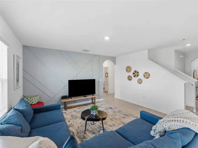 a living room with furniture kitchen and a table