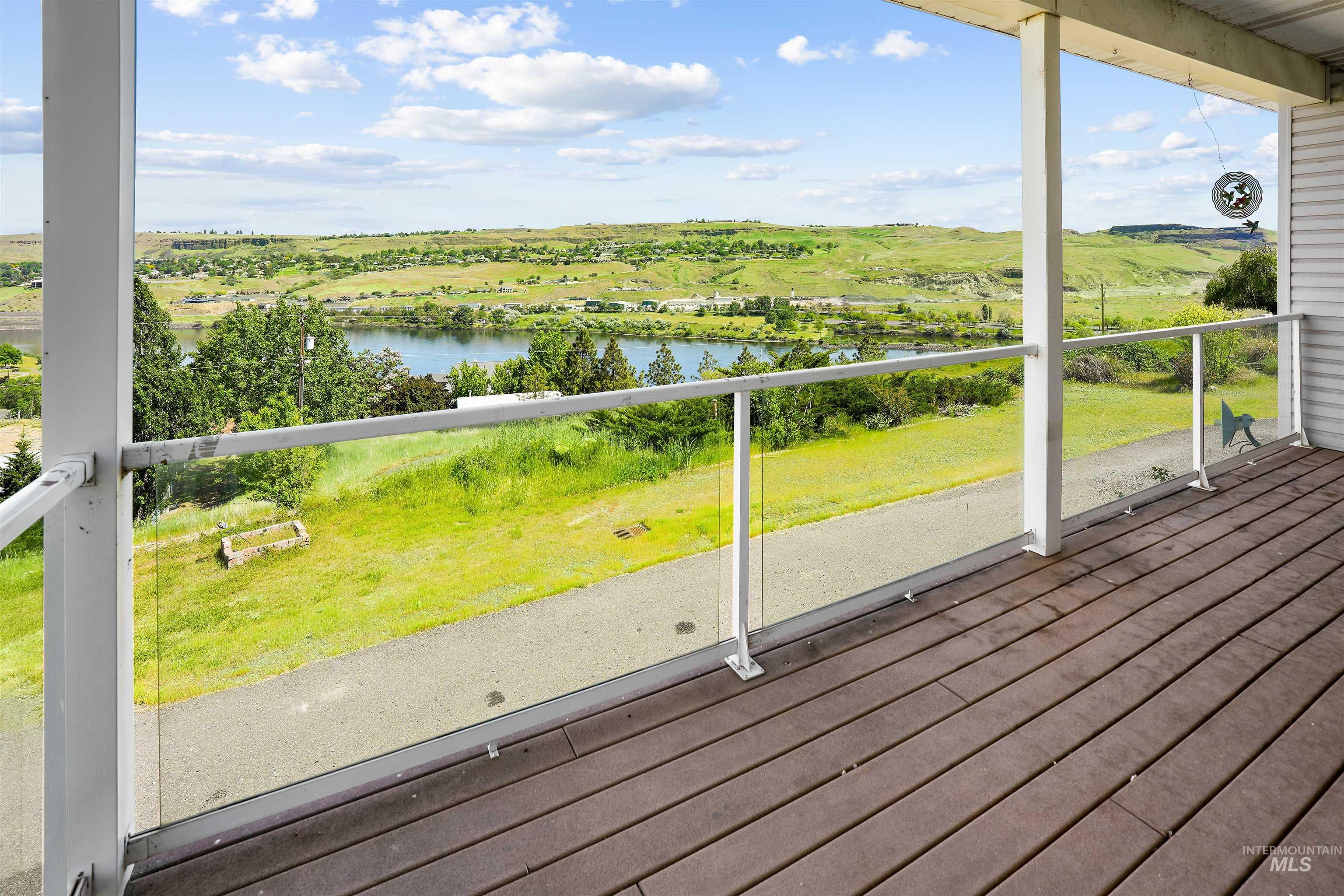 2750 South Perry Lane Clarkston, WA 99403 - Photo 7 of 47 Covered deck with composite wood-finish flooring and clear glass panel railing