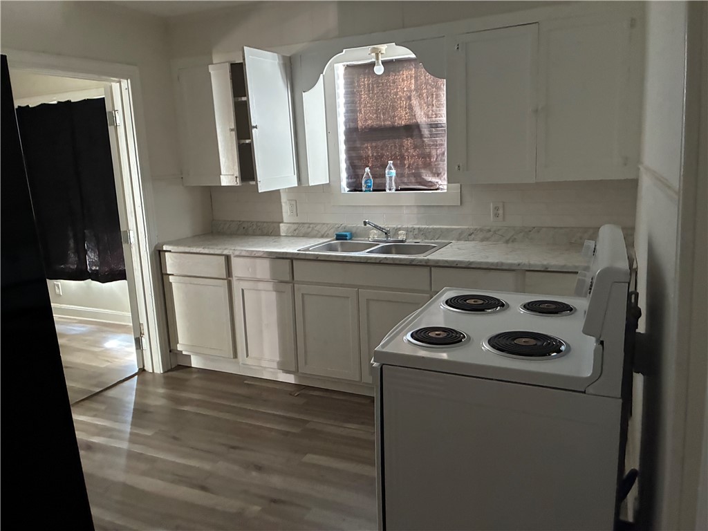 408 East 4th Street Alice, TX 78332 - Photo 12 of 14 a kitchen with a sink a stove and cabinets