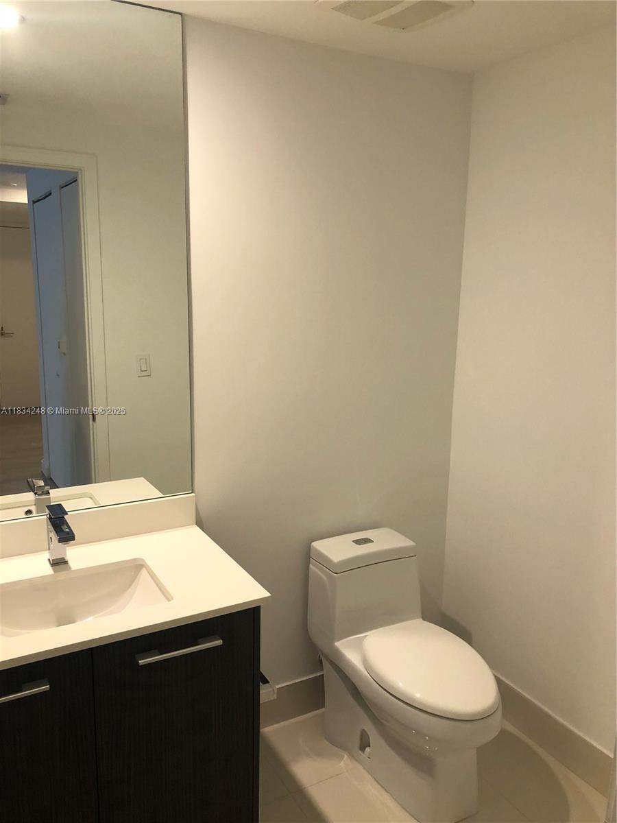 55 Southwest 9th Street, Unit 3009 Miami, FL 33130 - Photo 12 of 15 a bathroom with a sink a toilet and mirror