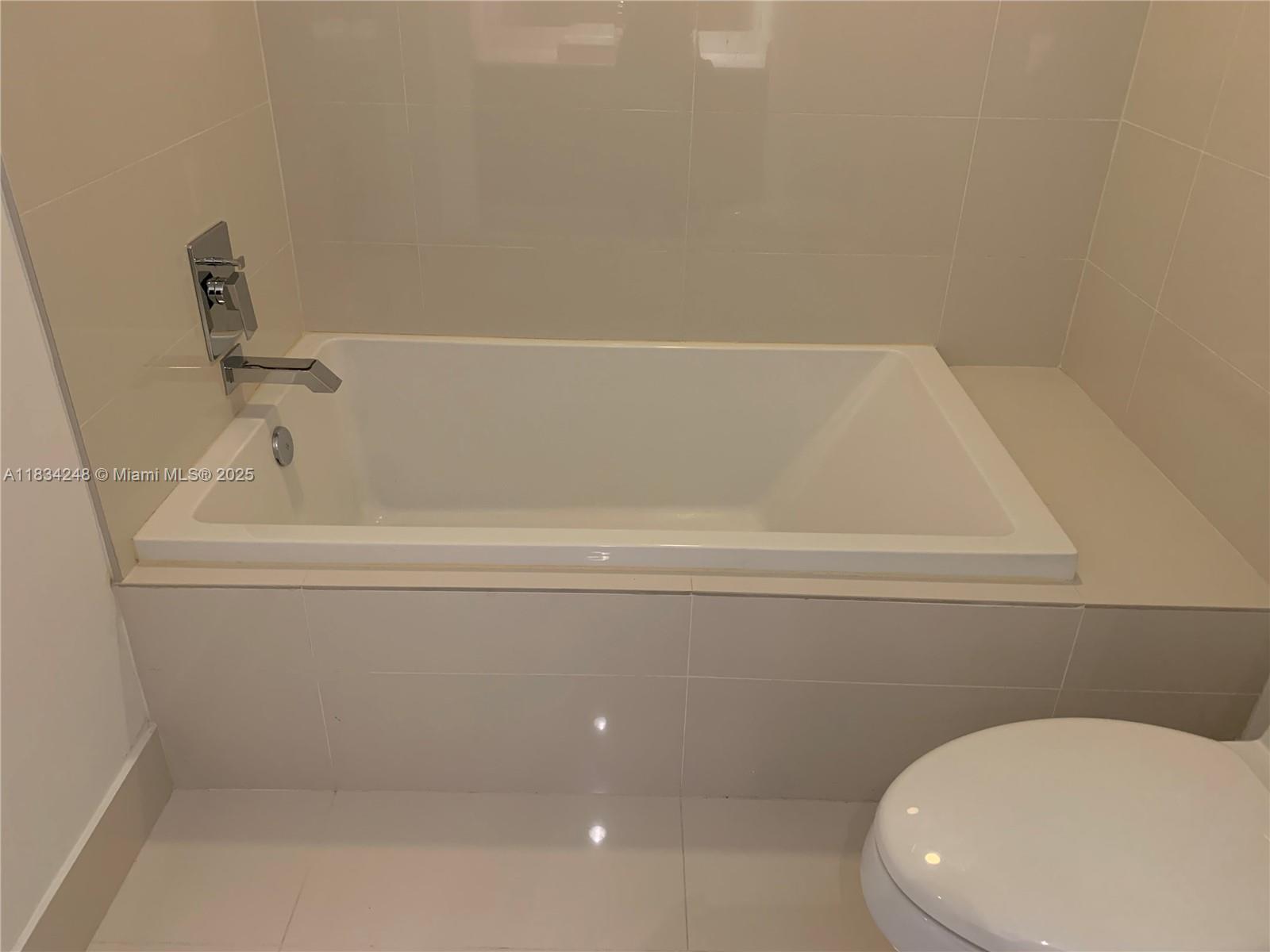 55 Southwest 9th Street, Unit 3009 Miami, FL 33130 - Photo 13 of 15 a bathroom with a toilet and bathtub