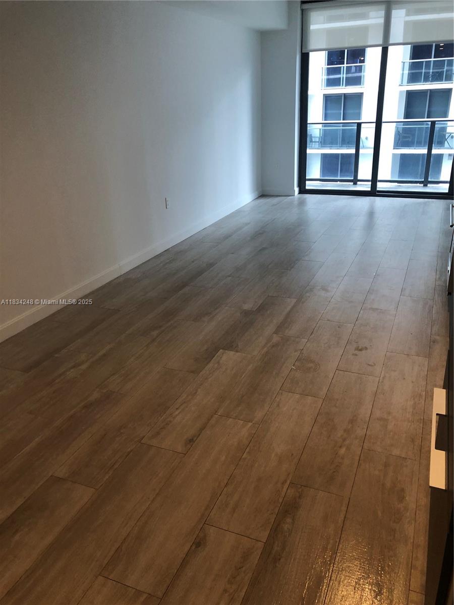 55 Southwest 9th Street, Unit 3009 Miami, FL 33130 - Photo 10 of 15 an empty room with wooden floor and windows