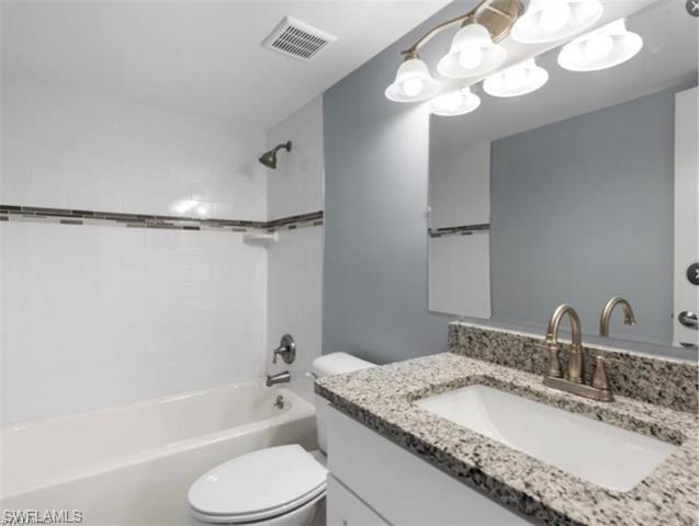 4900 Biscayne Drive, Unit 23 Naples, FL 34112 - Photo 12 of 21 Full bathroom with tiled shower / bath combo, vanity, and toilet