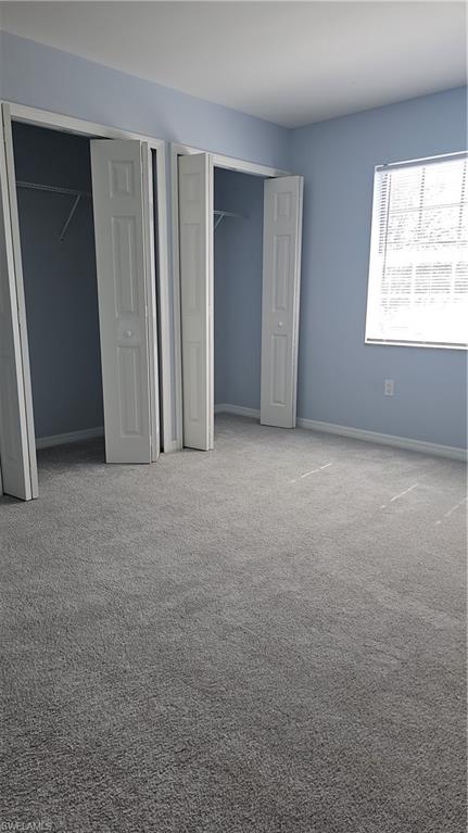 4900 Biscayne Drive, Unit 23 Naples, FL 34112 - Photo 15 of 21 Unfurnished bedroom with multiple closets and carpet
