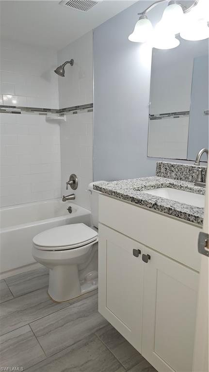 4900 Biscayne Drive, Unit 23 Naples, FL 34112 - Photo 17 of 21 Full bathroom with vanity, tiled shower / bath, and toilet
