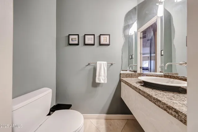 a spacious bathroom with a granite countertop toilet a sink and a mirror