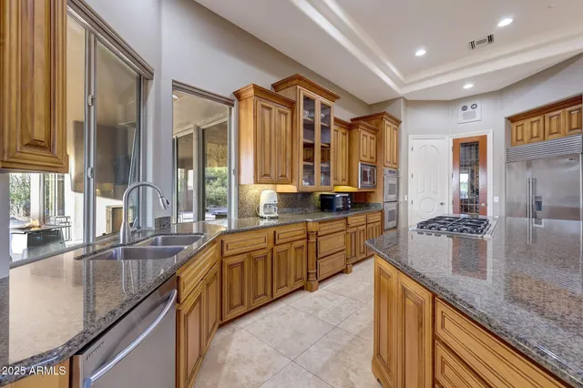 a large kitchen with granite countertop a sink and cabinets