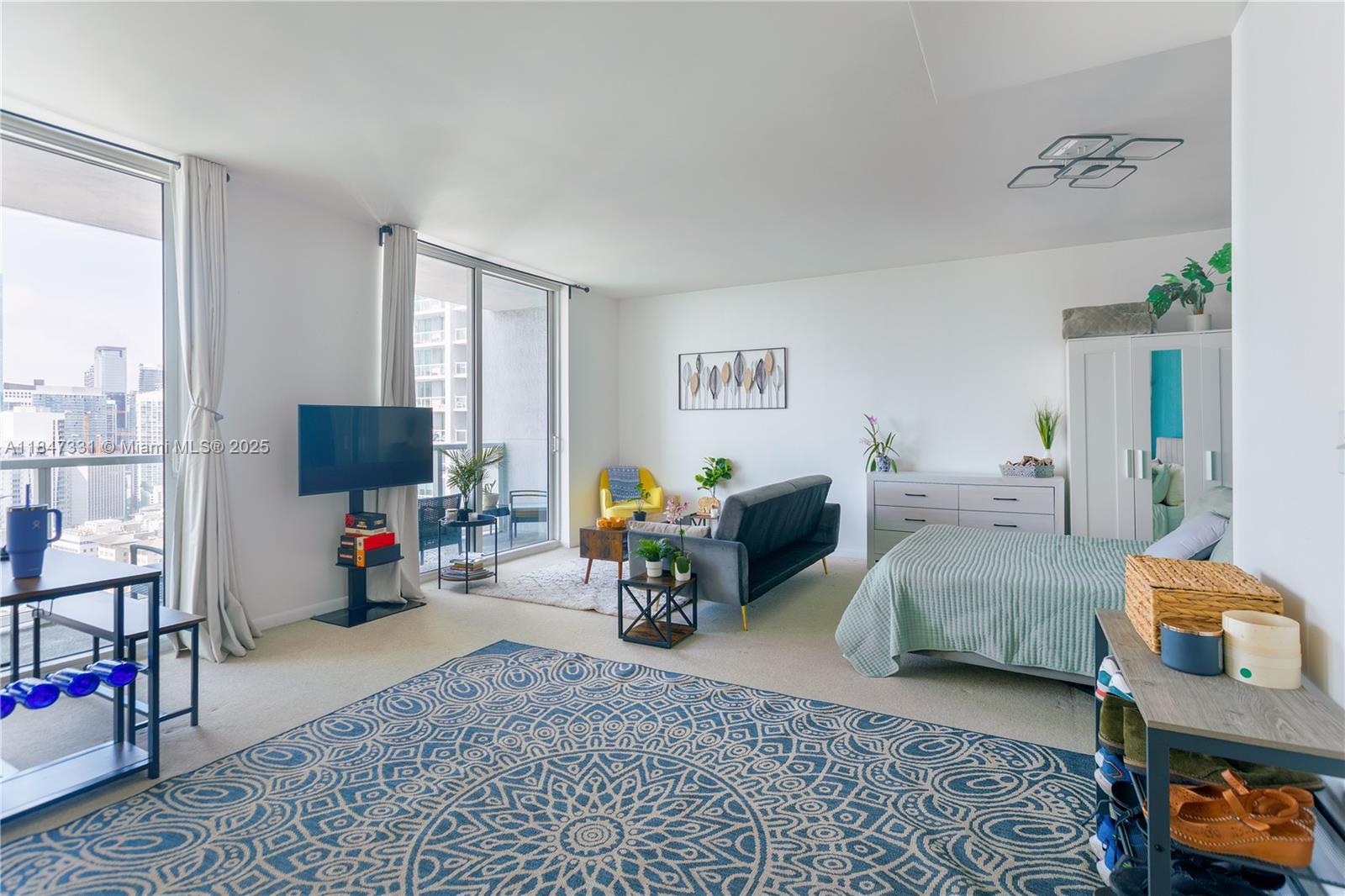 244 Biscayne Boulevard, Unit 3205 Miami, FL 33132 - Photo 4 of 10 a bed room with furniture and a flat screen tv