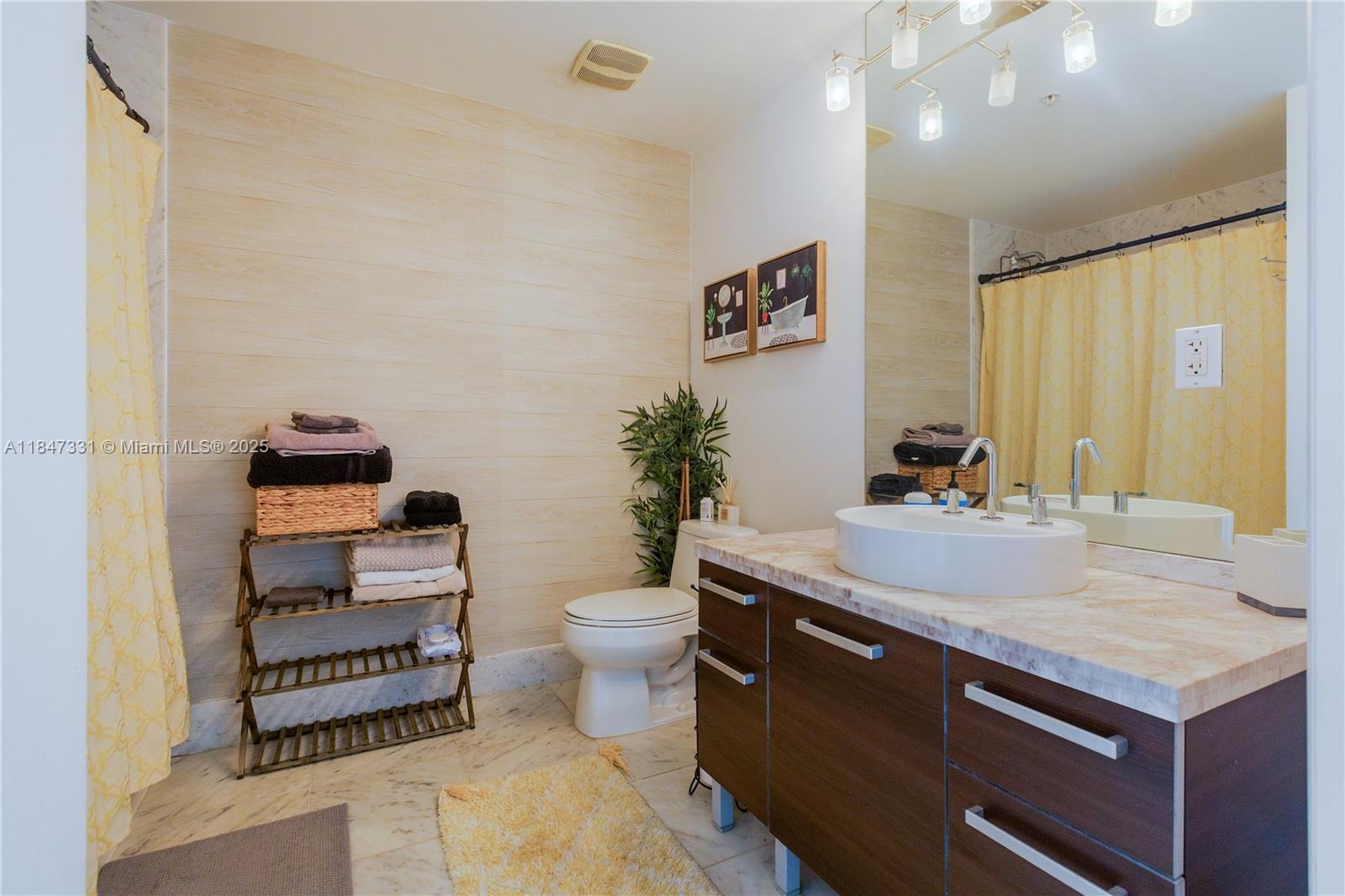 244 Biscayne Boulevard, Unit 3205 Miami, FL 33132 - Photo 8 of 10 a bathroom with a sink a toilet and mirror