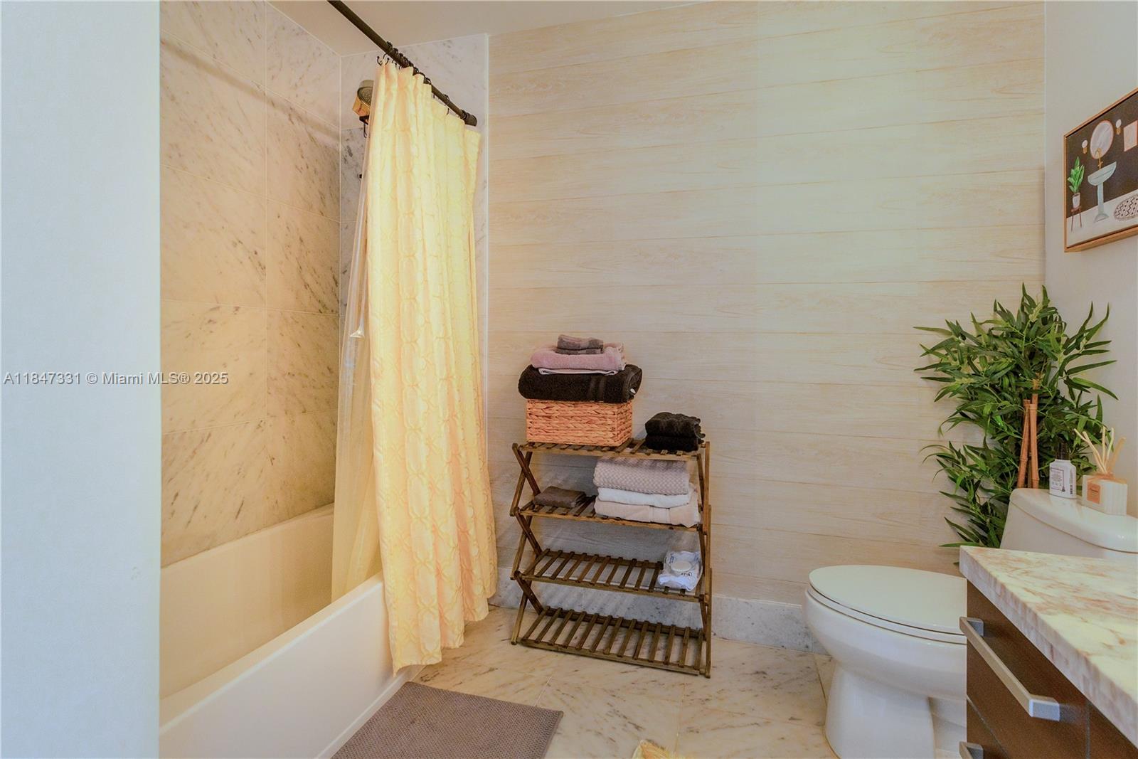 244 Biscayne Boulevard, Unit 3205 Miami, FL 33132 - Photo 9 of 10 a bathroom with a toilet and a shower curtain