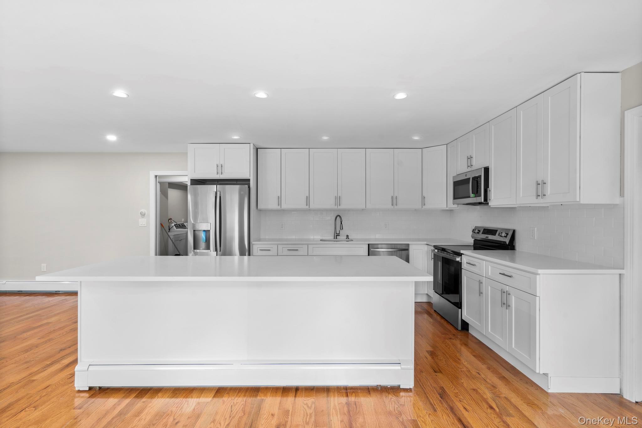 513 Bedford Road Armonk, NY 10504 - Photo 13 of 38 a kitchen with a sink a stove a refrigerator and white cabinets