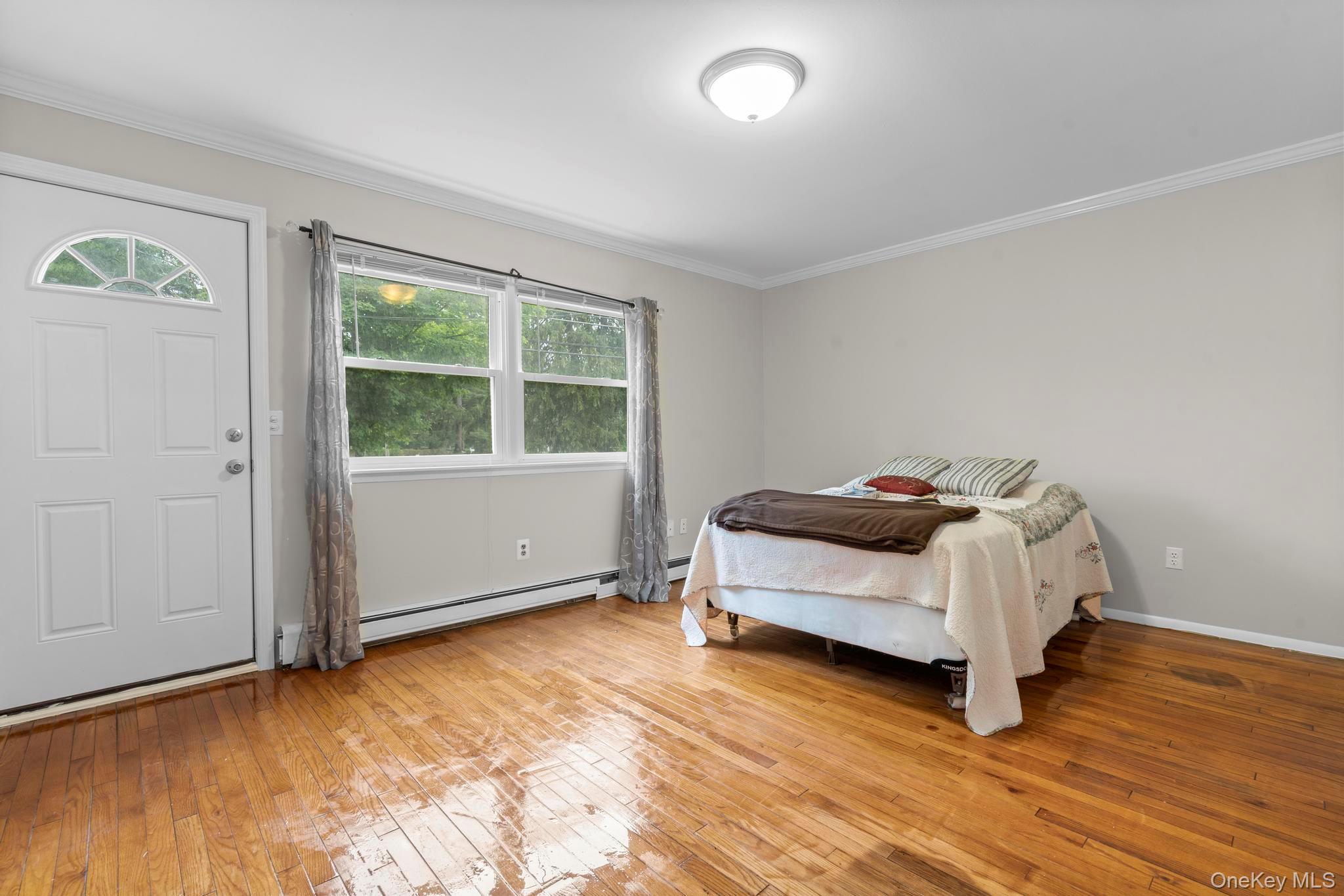 513 Bedford Road Armonk, NY 10504 - Photo 21 of 38 Bedroom with crown molding, a baseboard heating unit, and light wood-style floors