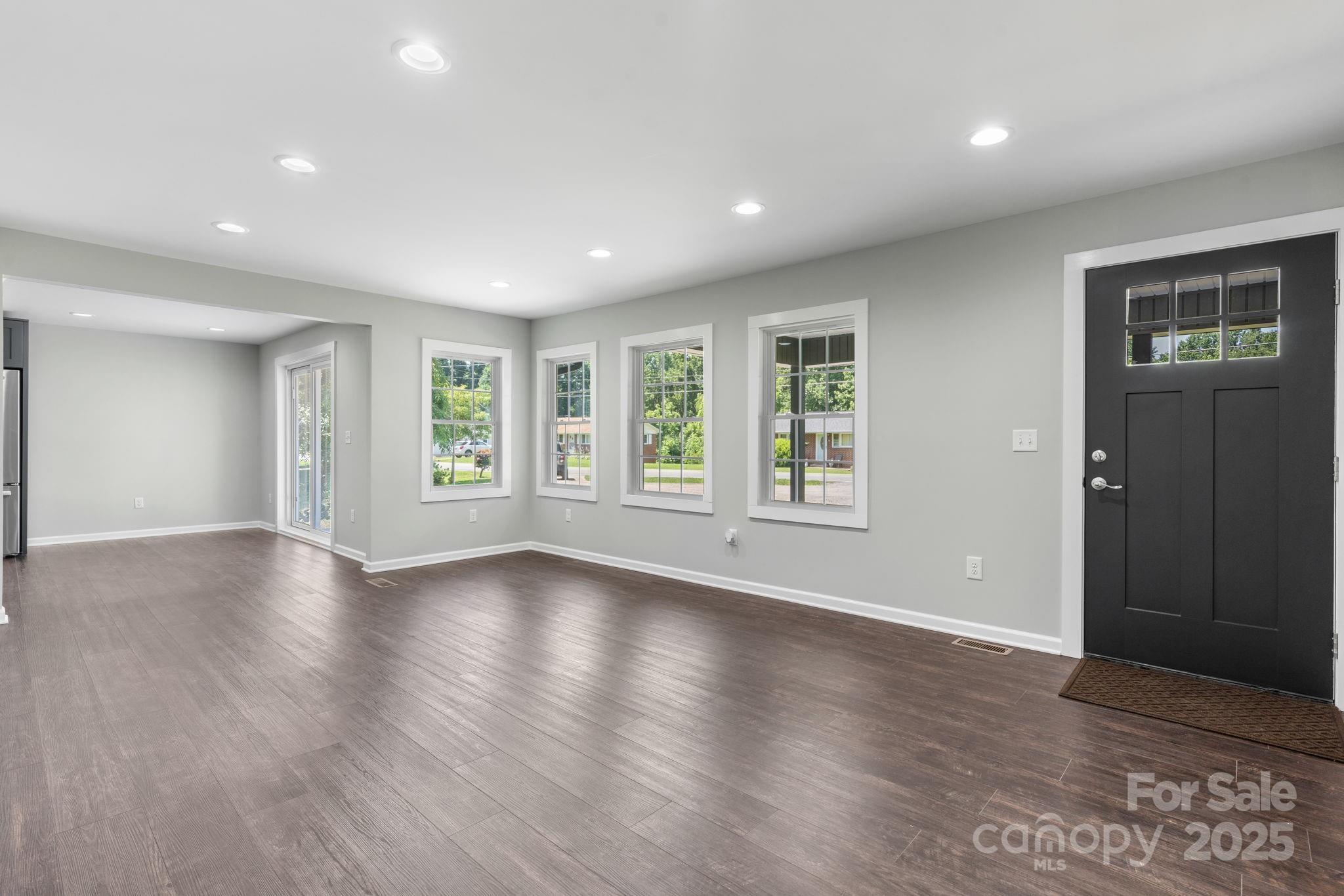 191 Harmony Grove Road Nebo, NC 28761 - Photo 17 of 47 an empty room with wooden floor and windows