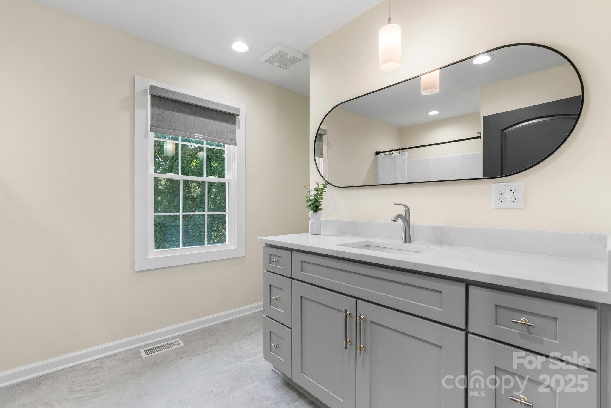 191 Harmony Grove Road Nebo, NC 28761 - Photo 23 of 47 a bathroom with a granite countertop sink a mirror and vanity