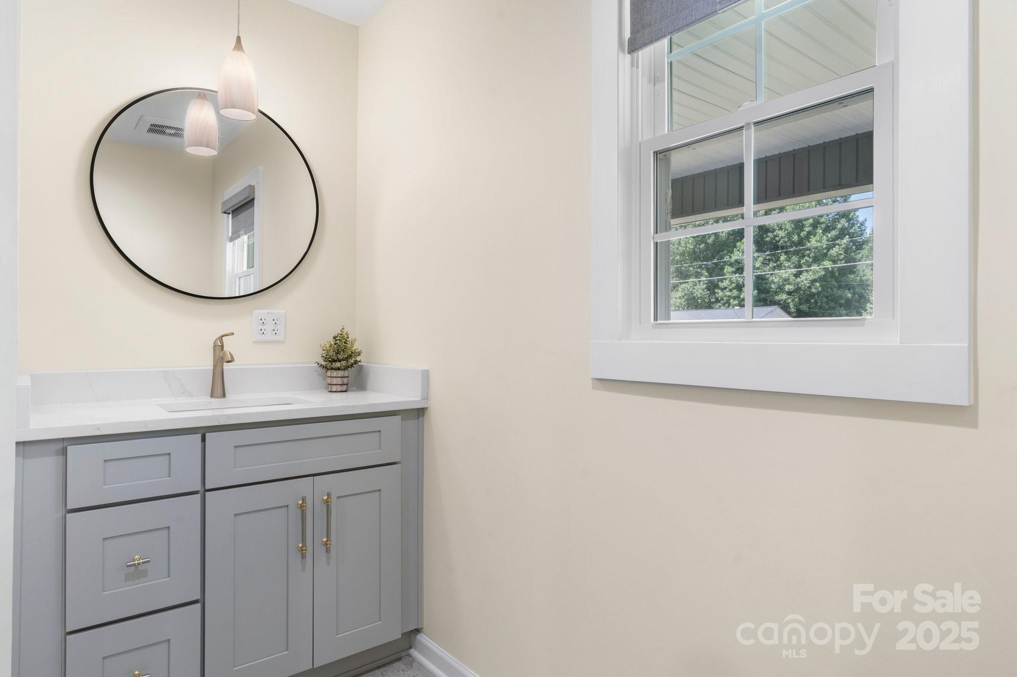 191 Harmony Grove Road Nebo, NC 28761 - Photo 27 of 47 a bathroom with a sink a mirror a vanity and a window