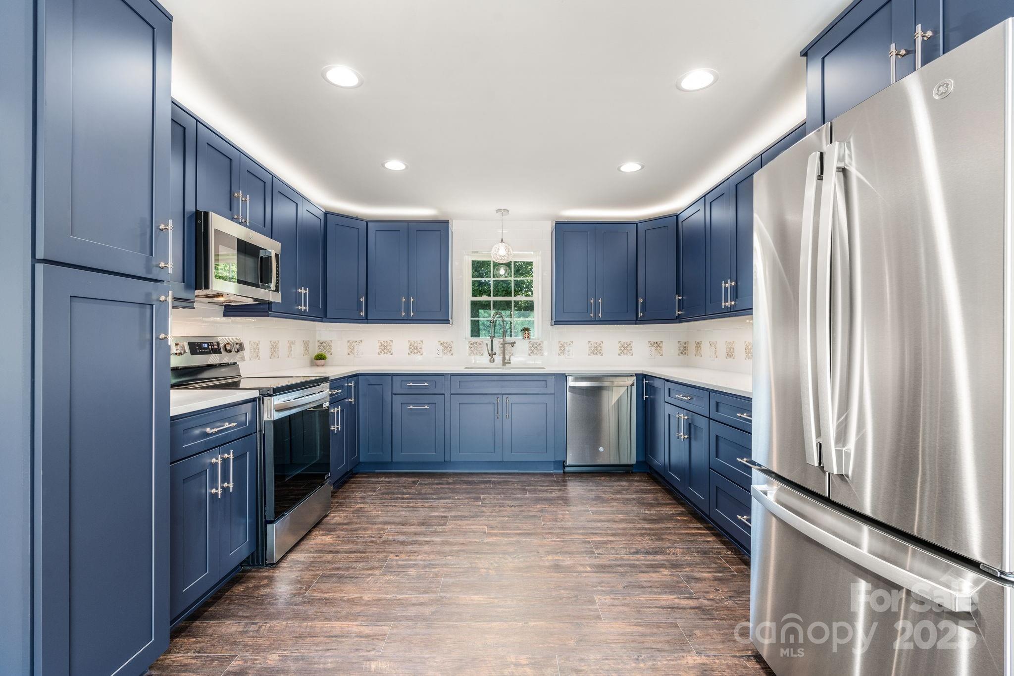 191 Harmony Grove Road Nebo, NC 28761 - Photo 39 of 47 a kitchen with stainless steel appliances granite countertop wooden cabinets a stove top oven a sink and dishwasher