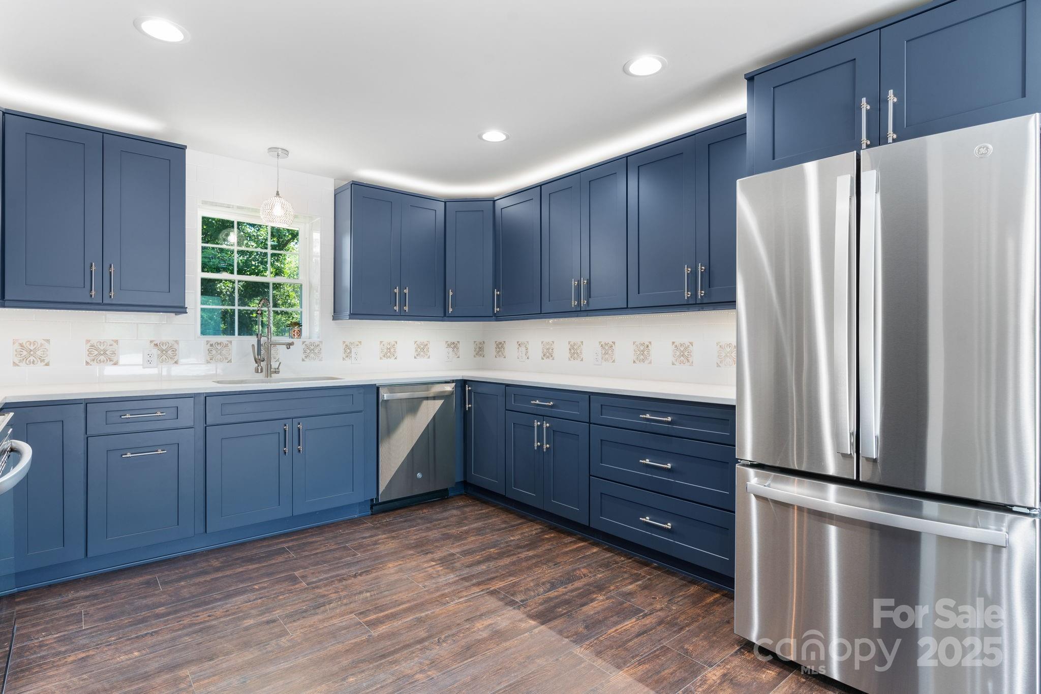 191 Harmony Grove Road Nebo, NC 28761 - Photo 42 of 47 a kitchen with stainless steel appliances granite countertop a refrigerator a sink a stove a microwave and wooden cabinets
