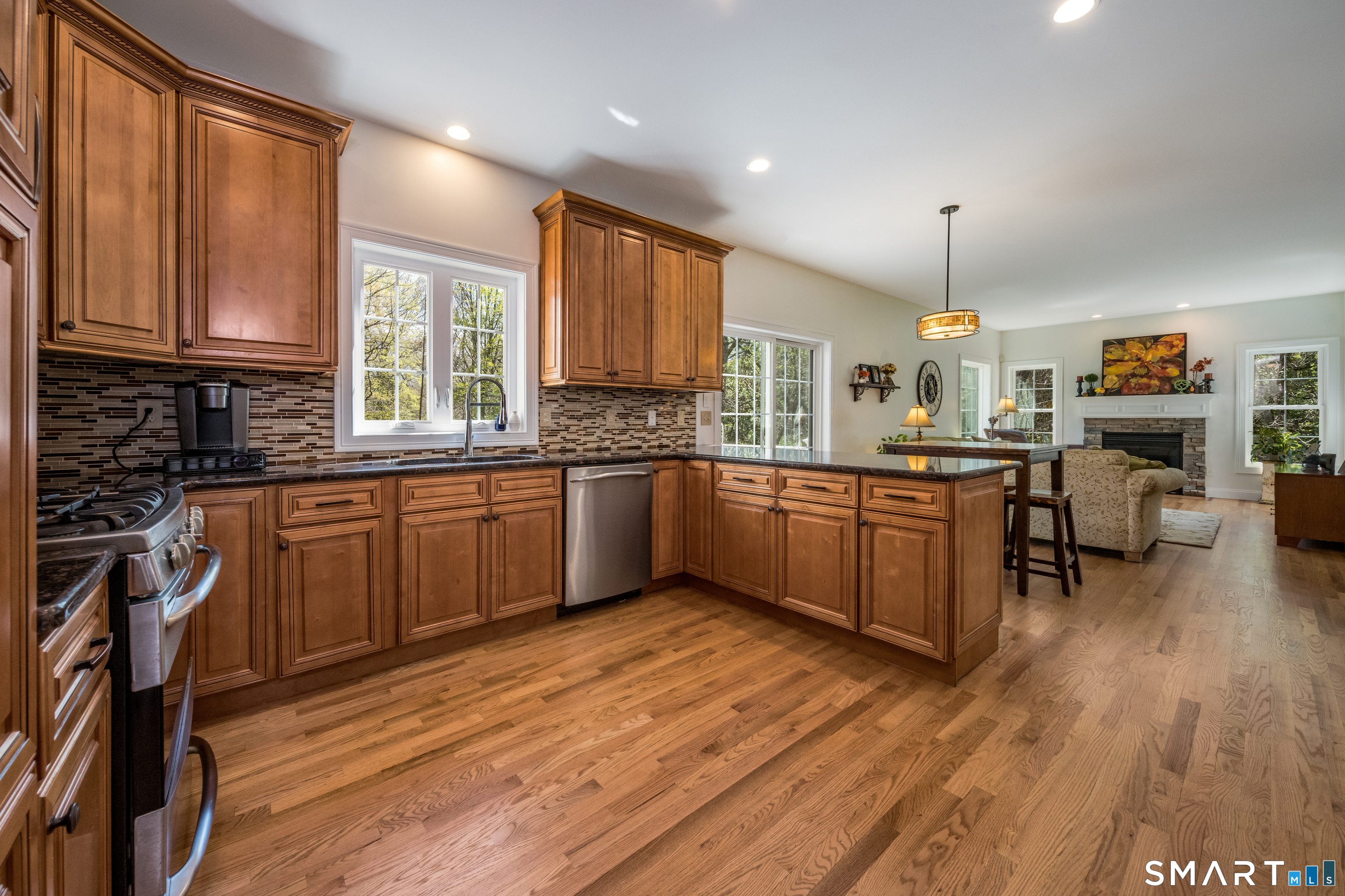 463 Tanner Marsh Road Guilford, CT 06437 - Photo 5 of 40 a kitchen with stainless steel appliances granite countertop wooden cabinets a sink dishwasher a stove and a refrigerator with wooden floor