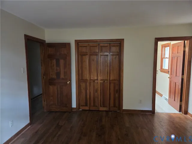 a view of a refrigerator in kitchen and an empty room