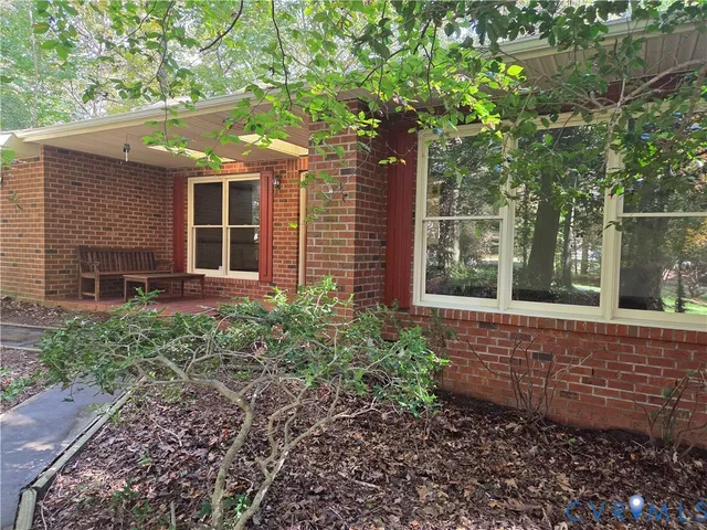 a view of a house with a yard and large tree