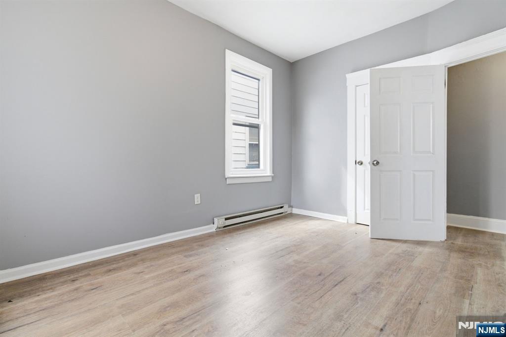 76 Grace Street Irvington, NJ 07111 - Photo 13 of 20 an empty room with wooden floor and windows