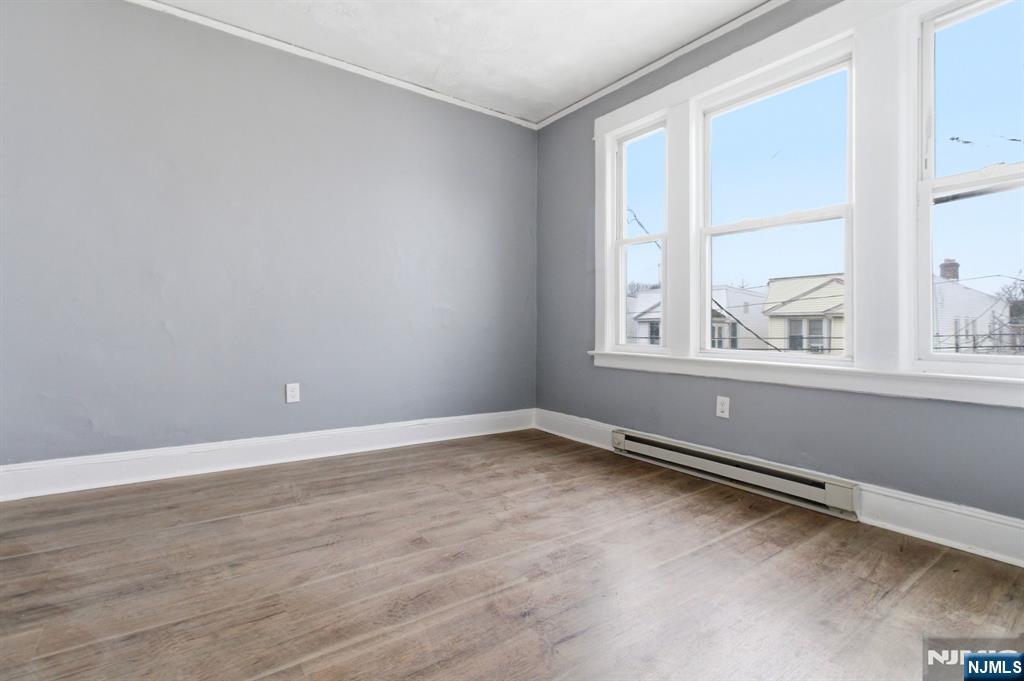 76 Grace Street Irvington, NJ 07111 - Photo 16 of 20 an empty room with wooden floor and windows