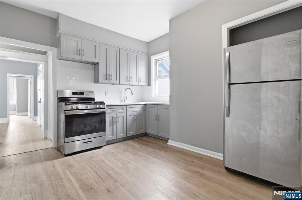 76 Grace Street Irvington, NJ 07111 - Photo 9 of 20 a kitchen with granite countertop a refrigerator and a stove top oven
