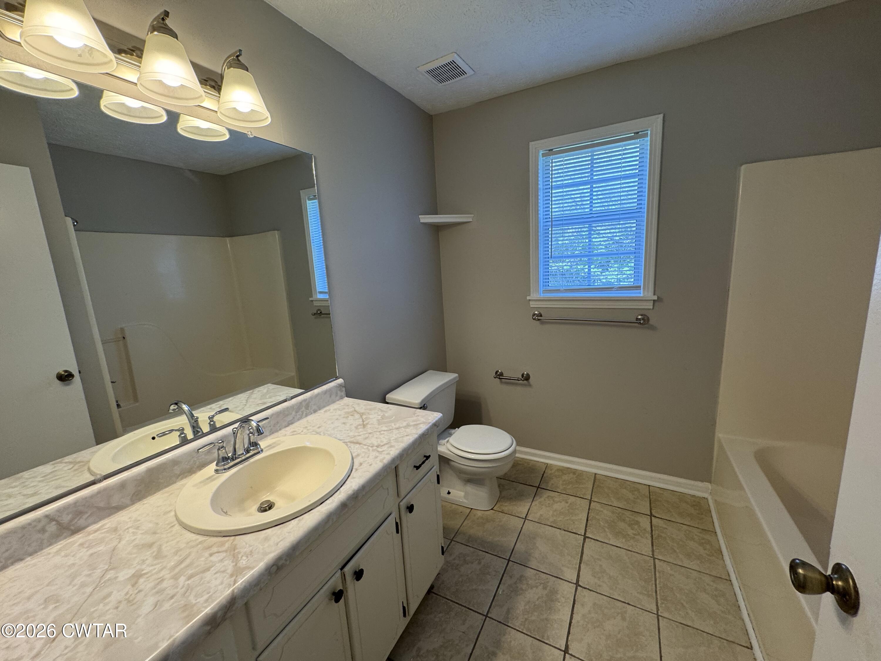 45 Ellendale Cove Jackson, TN 38305 - Photo 12 of 22 a bathroom with a granite countertop sink a toilet and a mirror