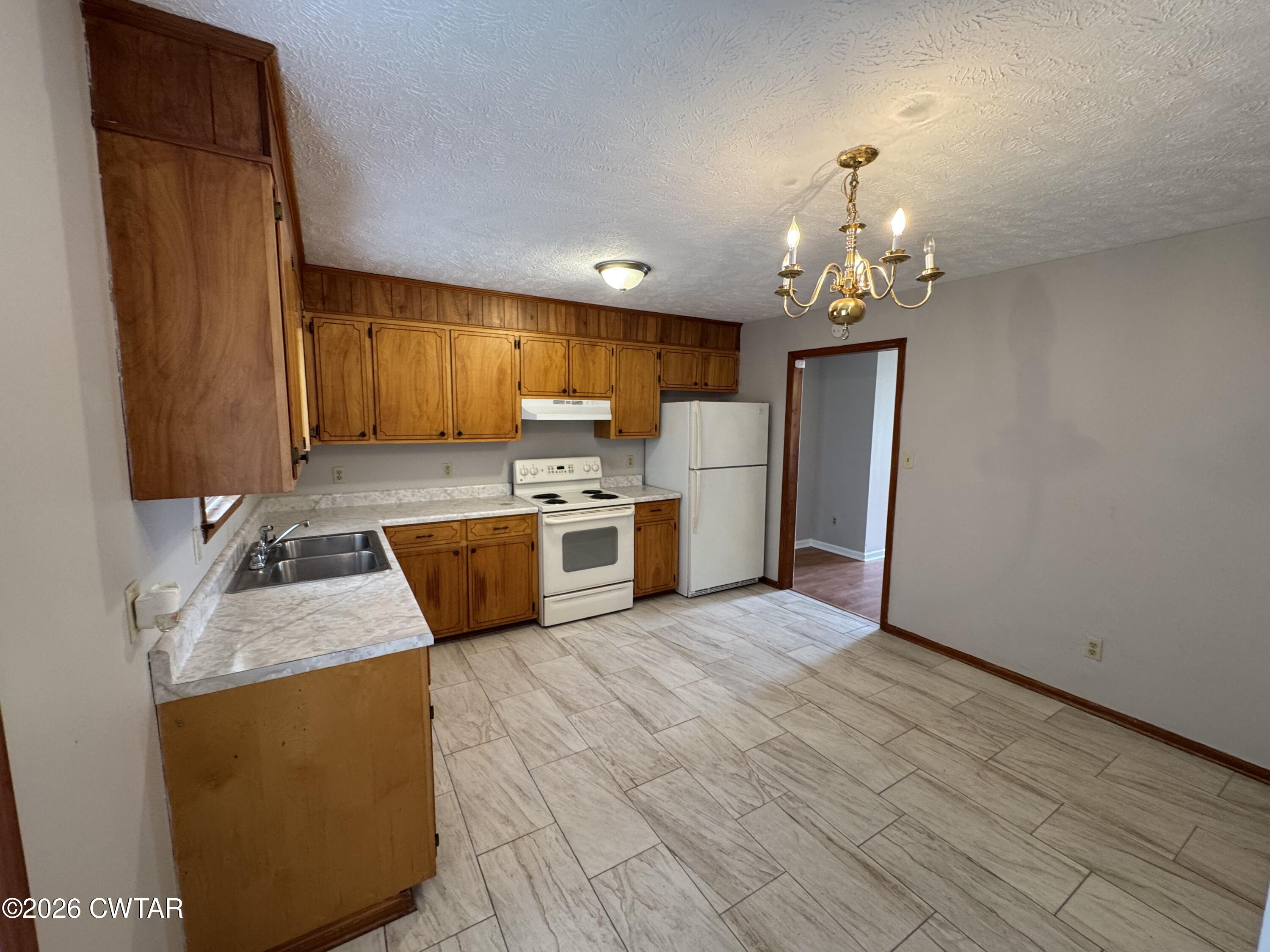 45 Ellendale Cove Jackson, TN 38305 - Photo 5 of 22 a kitchen with stainless steel appliances granite countertop a refrigerator a sink dishwasher a stove with wooden cabinets and floor
