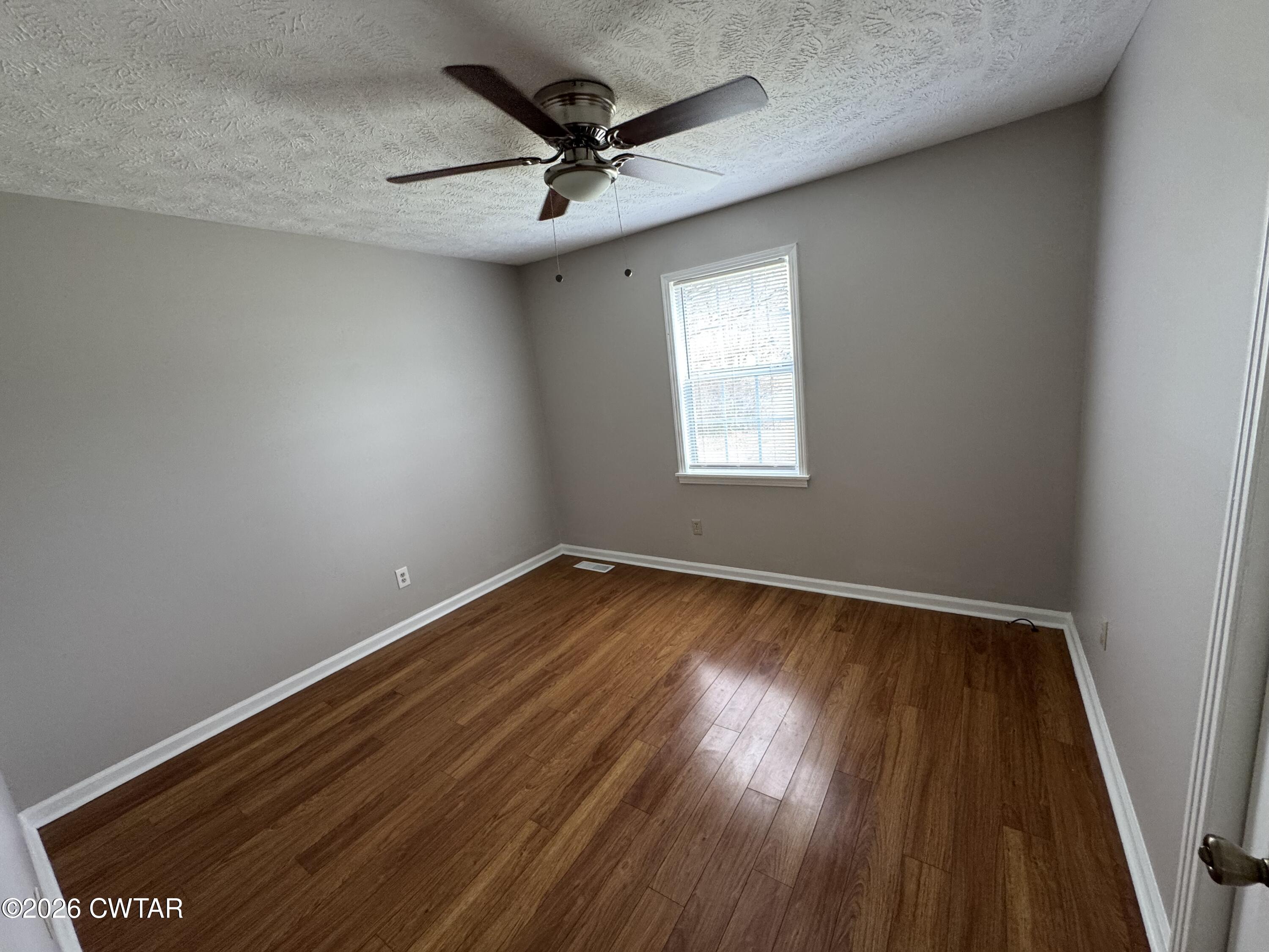 45 Ellendale Cove Jackson, TN 38305 - Photo 8 of 22 an empty room with wooden floor fan and windows