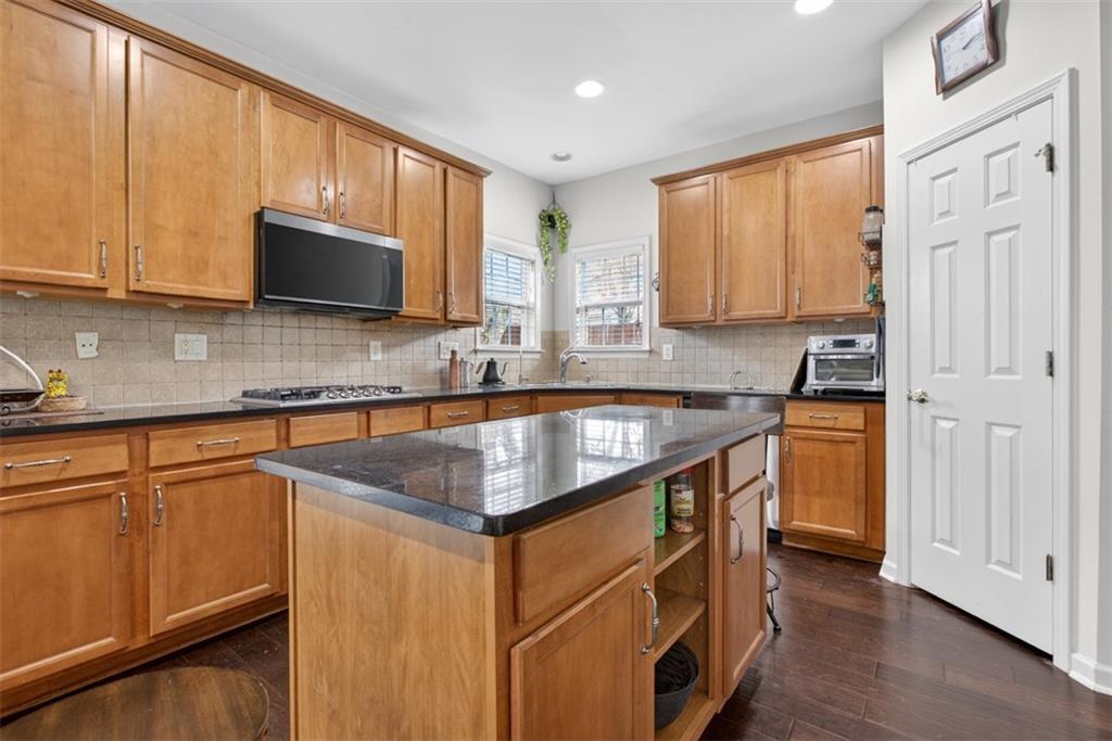 3210 Warbler Way Cumming, GA 30041 - Photo 15 of 45 a kitchen with stainless steel appliances granite countertop a sink a stove and a microwave