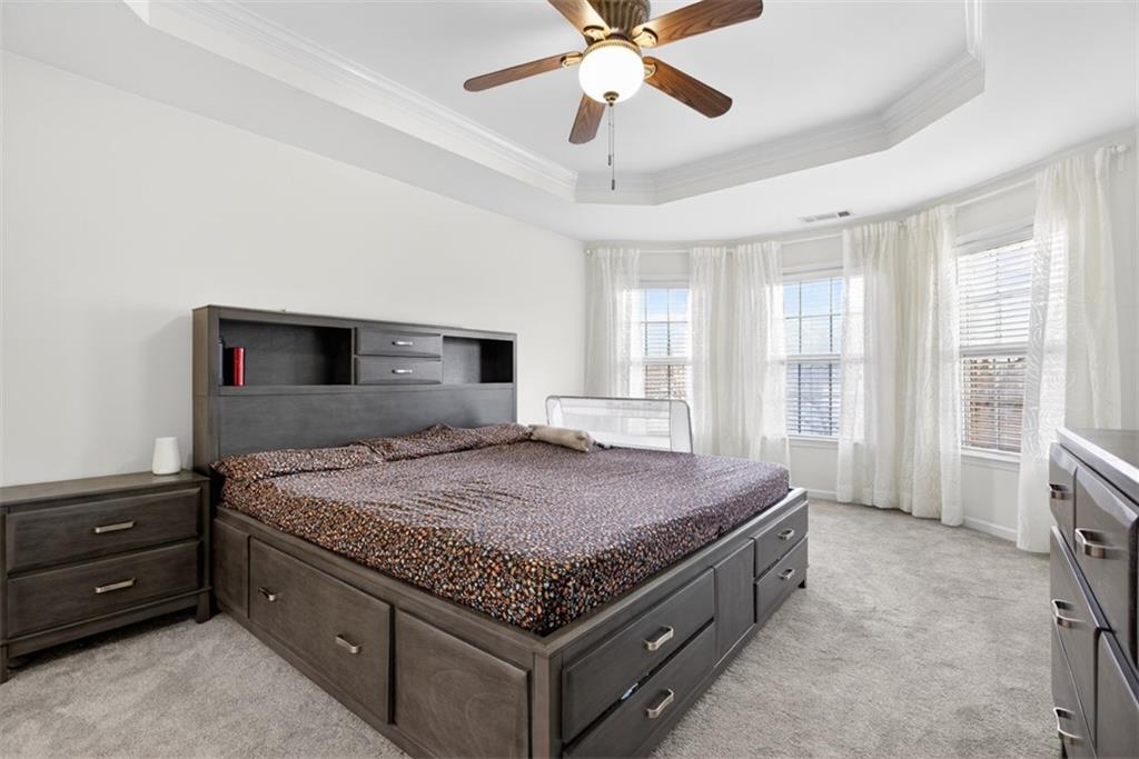 3210 Warbler Way Cumming, GA 30041 - Photo 34 of 45 a spacious bedroom with a bed and a chandelier